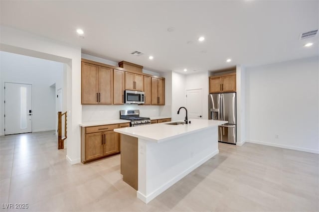 kitchen featuring sink, stainless steel appliances, and an island with sink