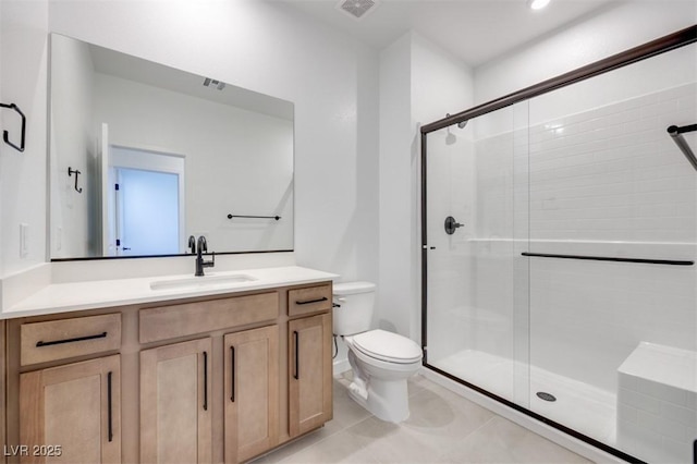 bathroom with vanity, tile patterned floors, a shower with door, and toilet