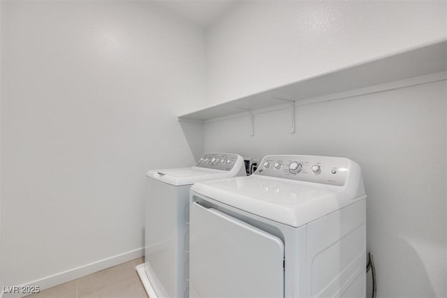 clothes washing area featuring light tile patterned floors and washing machine and clothes dryer