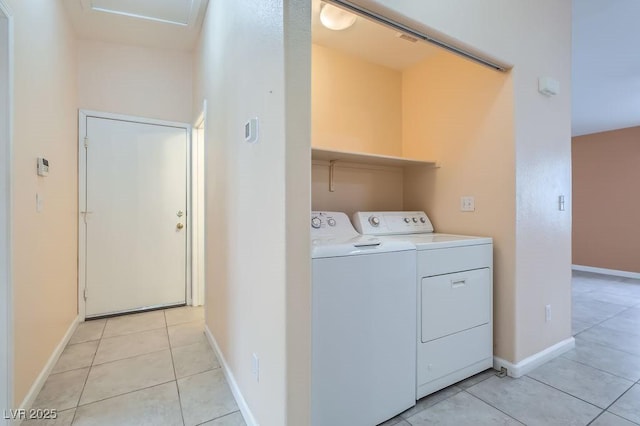 clothes washing area with washer and dryer and light tile patterned floors