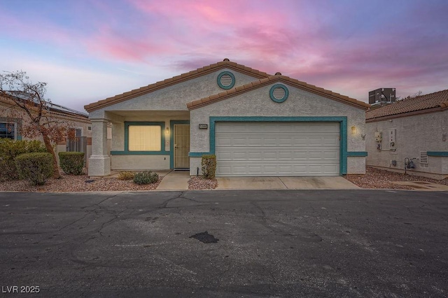 view of front of home featuring cooling unit and a garage