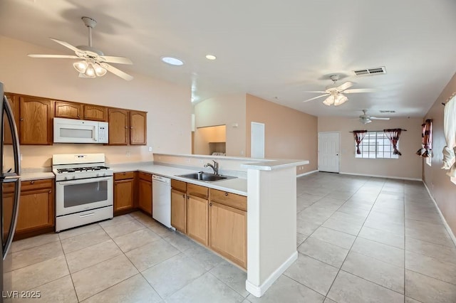 kitchen with sink, white appliances, light tile patterned floors, ceiling fan, and kitchen peninsula