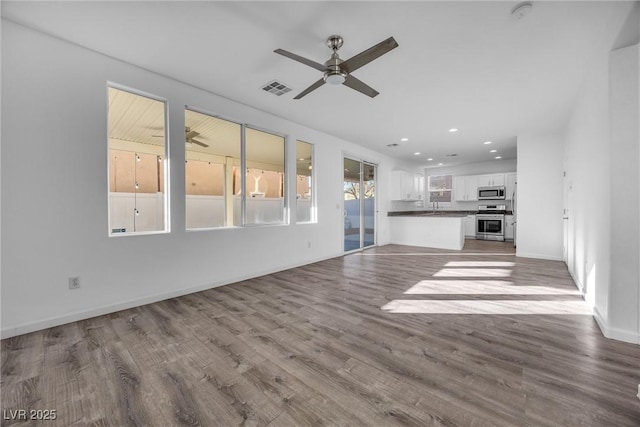 unfurnished living room with ceiling fan and light hardwood / wood-style flooring