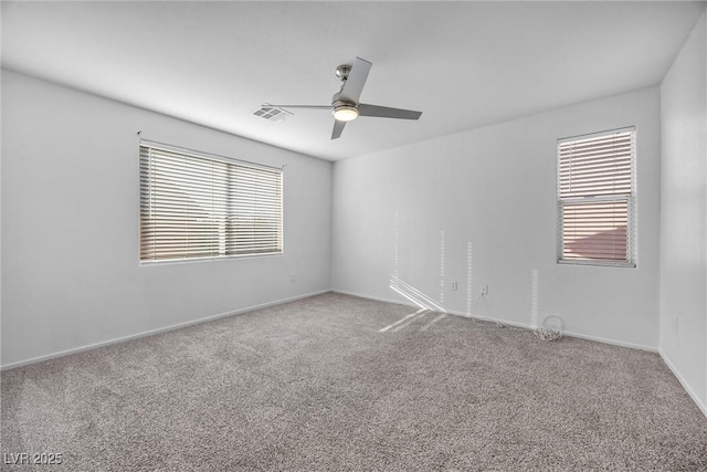 carpeted spare room featuring ceiling fan