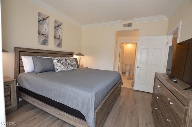 bedroom with ornamental molding, connected bathroom, and light hardwood / wood-style flooring