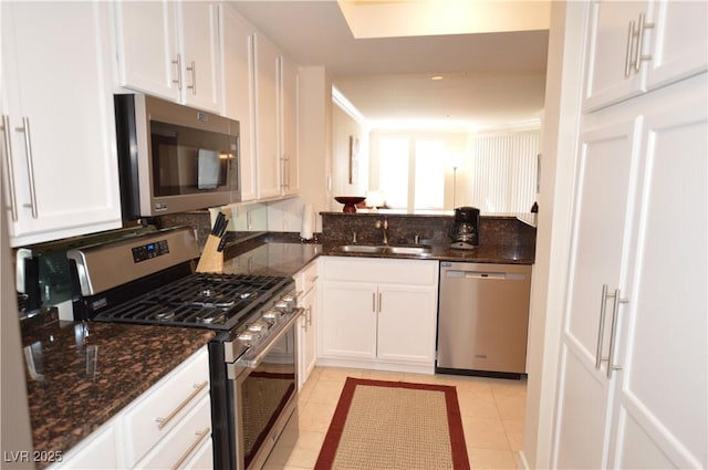 kitchen featuring sink, light tile patterned flooring, white cabinets, and appliances with stainless steel finishes