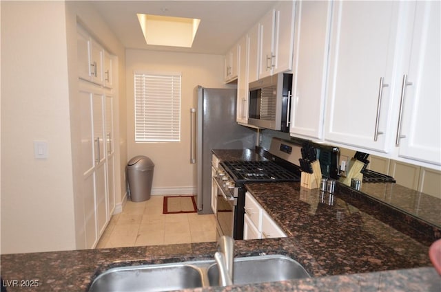 kitchen with white cabinetry, appliances with stainless steel finishes, sink, and light tile patterned flooring