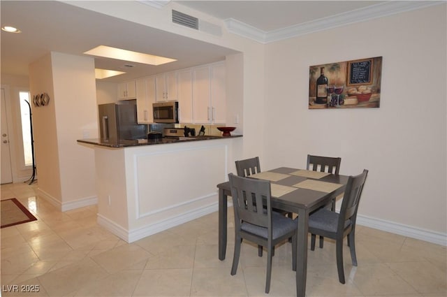 dining space with ornamental molding and light tile patterned flooring