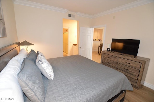 bedroom with crown molding, light wood-type flooring, and ensuite bathroom