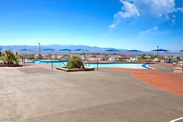 view of swimming pool with a patio and a mountain view