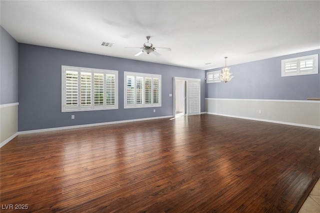 unfurnished room featuring dark hardwood / wood-style flooring and ceiling fan with notable chandelier