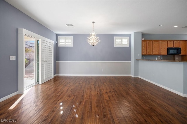 interior space with dark wood-type flooring, sink, and an inviting chandelier