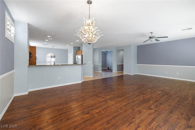 unfurnished living room with dark hardwood / wood-style floors and ceiling fan with notable chandelier