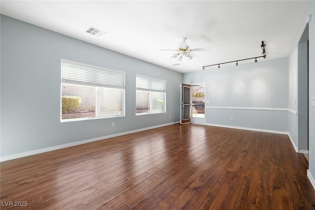 spare room with dark hardwood / wood-style flooring, rail lighting, and ceiling fan