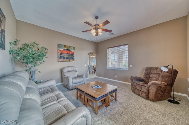 living area with visible vents, arched walkways, a ceiling fan, baseboards, and carpet