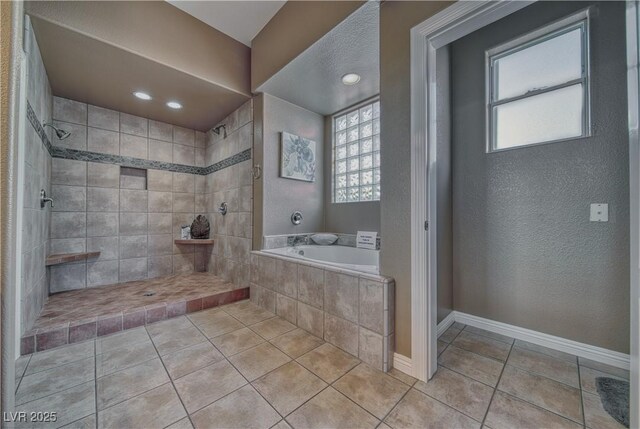 bathroom featuring independent shower and bath, plenty of natural light, and tile patterned flooring