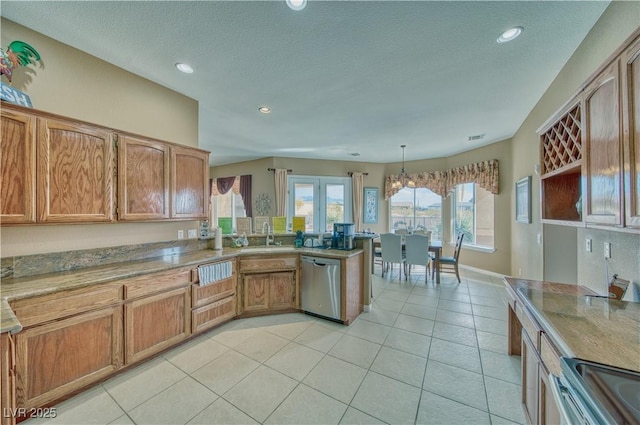 kitchen with decorative light fixtures, sink, light tile patterned floors, kitchen peninsula, and stainless steel appliances