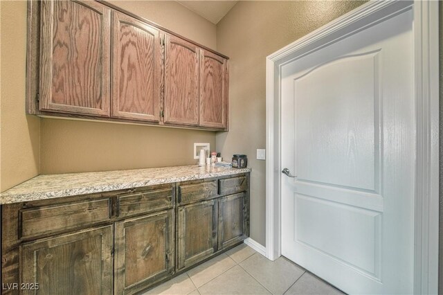 laundry room with hookup for a washing machine and light tile patterned floors