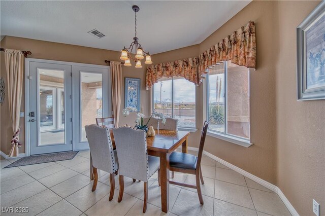 dining space with light tile patterned floors and a chandelier