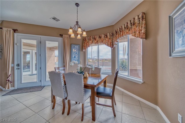 dining area with light tile patterned floors, baseboards, visible vents, and a notable chandelier