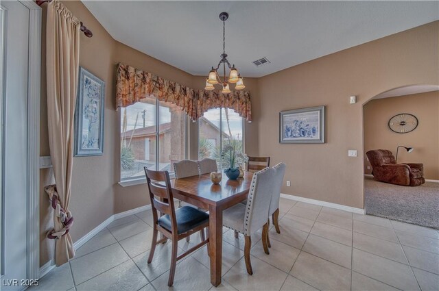 dining space featuring light tile patterned floors and an inviting chandelier