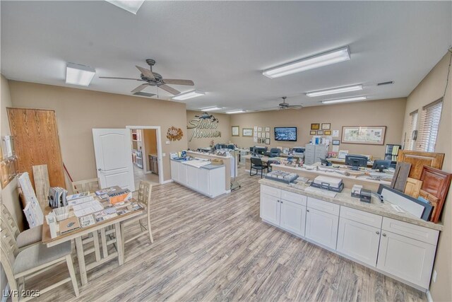 kitchen featuring white cabinetry, light stone countertops, ceiling fan, and light hardwood / wood-style floors