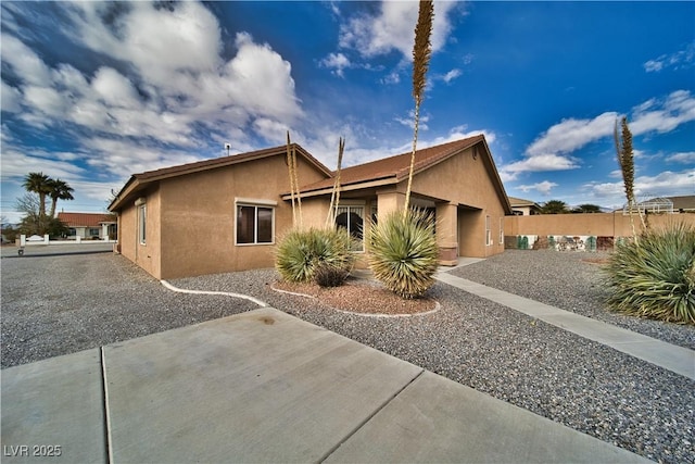 view of front of home featuring fence and stucco siding