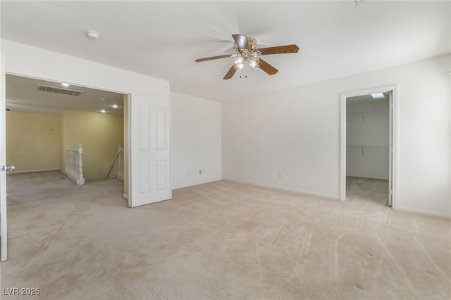 unfurnished room with light carpet, baseboards, visible vents, and a ceiling fan