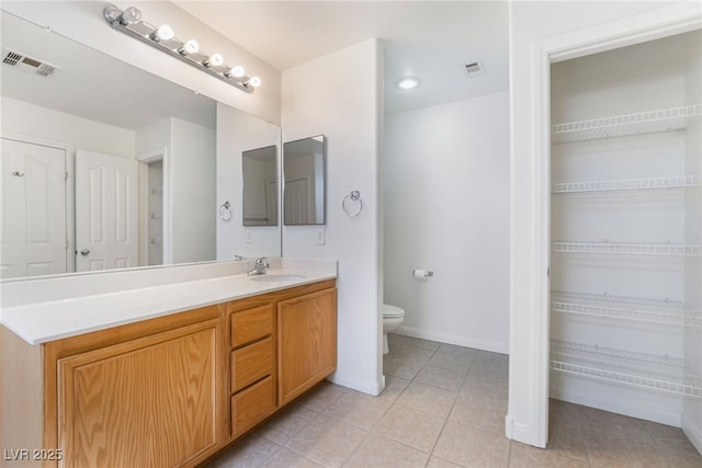 bathroom featuring visible vents, vanity, toilet, and tile patterned floors