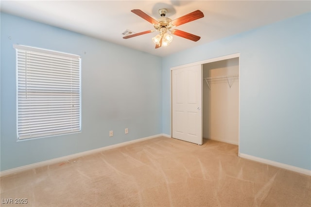 unfurnished bedroom with ceiling fan, light colored carpet, visible vents, baseboards, and a closet