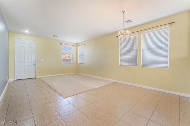 unfurnished room featuring light tile patterned floors, an inviting chandelier, visible vents, and baseboards