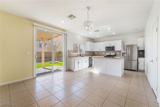 kitchen with recessed lighting, a sink, white cabinetry, light countertops, and appliances with stainless steel finishes