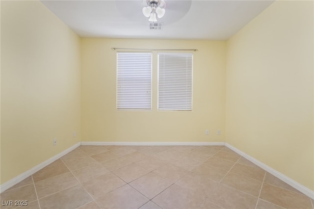 spare room with ceiling fan, visible vents, and baseboards