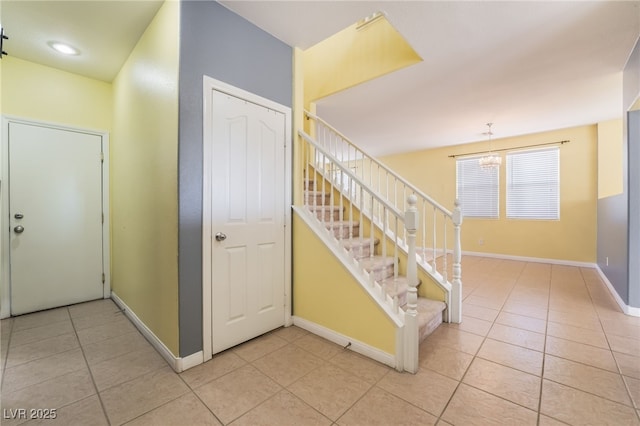 stairway featuring baseboards and tile patterned floors