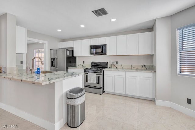 kitchen with sink, light stone counters, kitchen peninsula, stainless steel appliances, and white cabinets