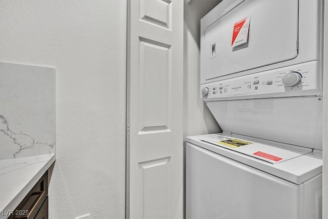 washroom with stacked washing maching and dryer