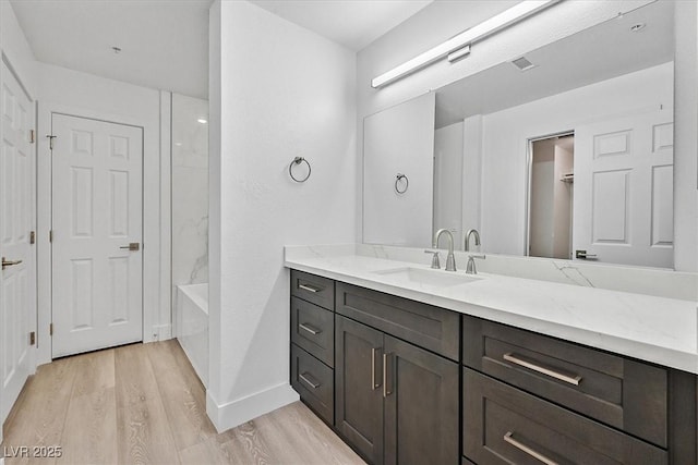 bathroom with vanity, wood-type flooring, and  shower combination