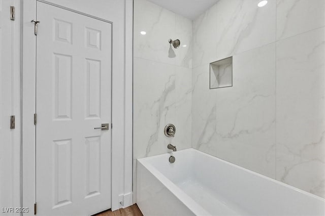 bathroom featuring tiled shower / bath combo and hardwood / wood-style flooring