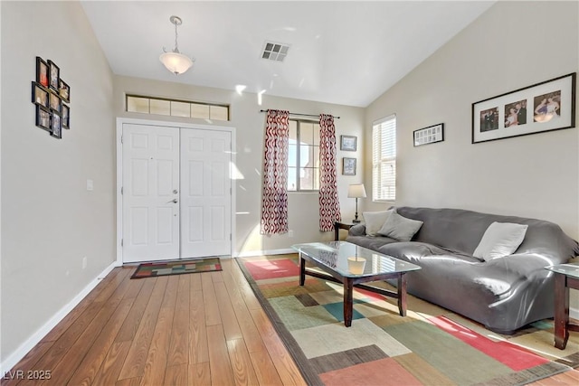 living room with vaulted ceiling and light wood-type flooring