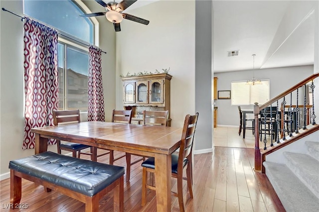 dining room featuring hardwood / wood-style flooring and ceiling fan with notable chandelier