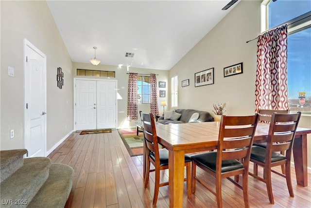 dining space with hardwood / wood-style flooring and high vaulted ceiling