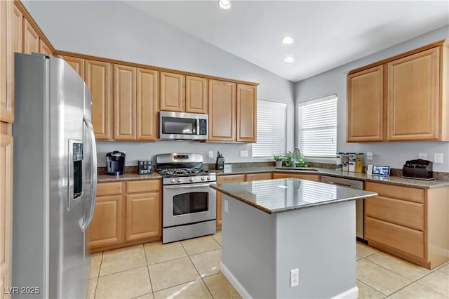 kitchen featuring lofted ceiling, sink, a center island, light tile patterned floors, and stainless steel appliances