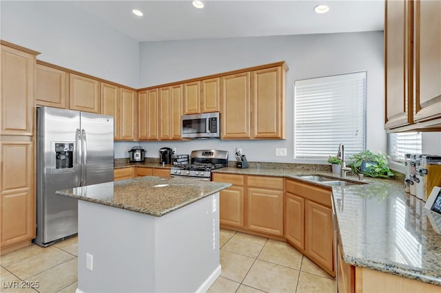 kitchen with sink, light tile patterned floors, appliances with stainless steel finishes, light stone counters, and a kitchen island