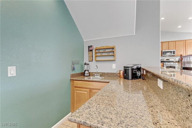 kitchen with light brown cabinetry, sink, stainless steel appliances, and light stone countertops