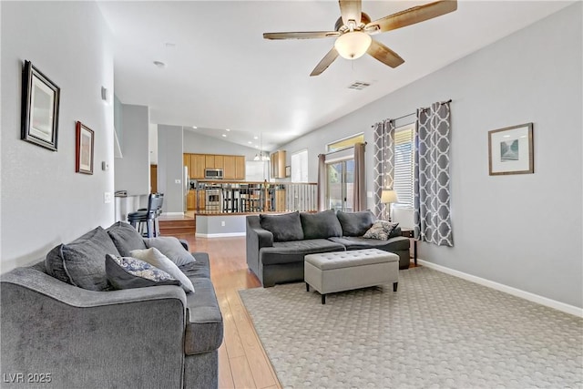 living room with ceiling fan, lofted ceiling, and light hardwood / wood-style floors