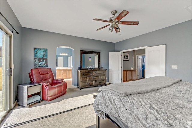 bedroom featuring ceiling fan, light colored carpet, and ensuite bath