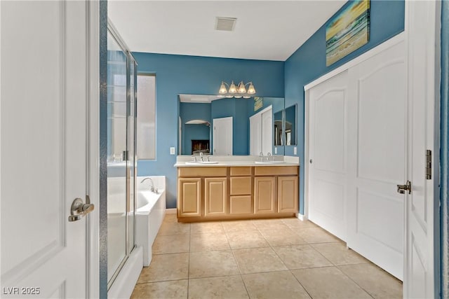 bathroom featuring tile patterned flooring, vanity, and separate shower and tub