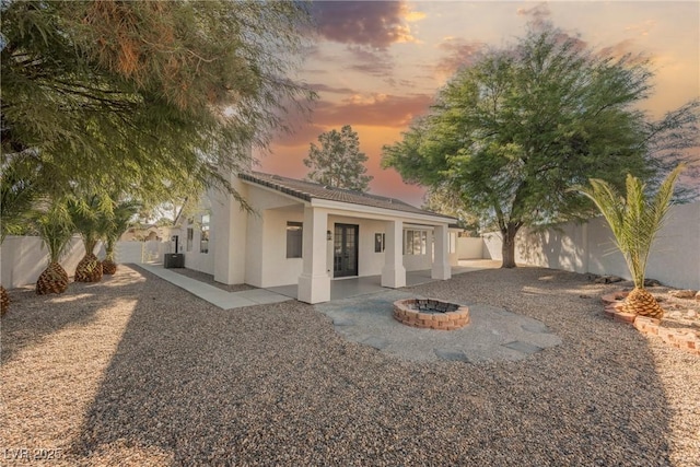 view of front of home featuring central AC unit, a fire pit, and a patio