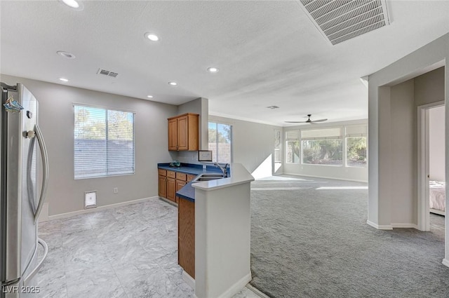 kitchen with light carpet, sink, a wealth of natural light, and stainless steel fridge