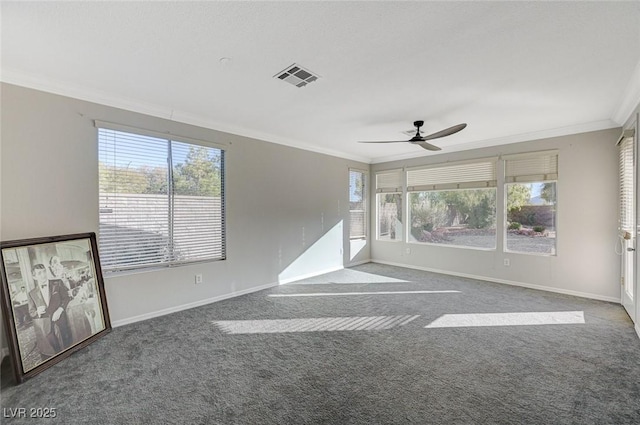 carpeted empty room with crown molding, a healthy amount of sunlight, and ceiling fan